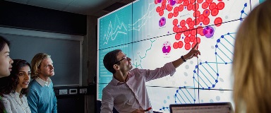 Professor showing students scientific diagram on classroom projector